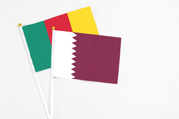 Qatar and Cameroon stick flags on white background. High quality fabric, miniature national flag. Peaceful global concept.White floor for copy space.