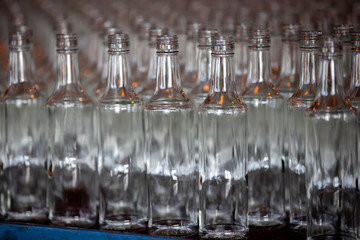 Glassworks. Glass industry. Many glass bottles on a factory conveyor.