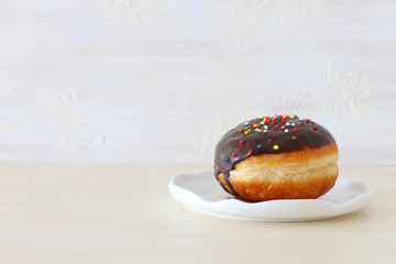 Image of jewish holiday Hanukkah with traditional doughnut on the table
