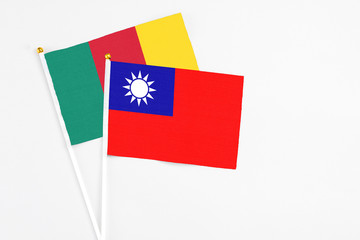 Taiwan and Cameroon stick flags on white background. High quality fabric, miniature national flag. Peaceful global concept.White floor for copy space.
