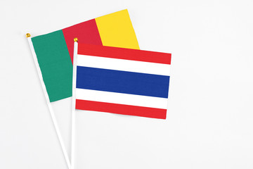Thailand and Cameroon stick flags on white background. High quality fabric, miniature national flag. Peaceful global concept.White floor for copy space.