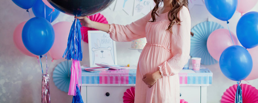 pregnant woman near pink and blue decorations at gender reveal party