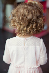 little curly girl in pink dress