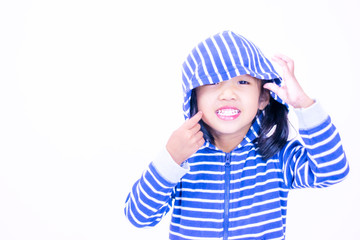 A little girl with a smiling face, aged three and a half wearing a blue sweate