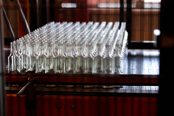 Glassworks. Many glass bottles on conveyor belt before packing