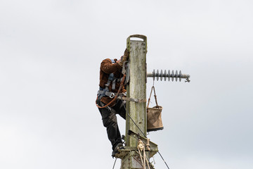 View of a man working on welding on top of an iron railroad tower