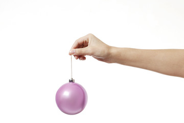 Christmas pink toy ball for the Christmas tree  in hand isolated on a white background.