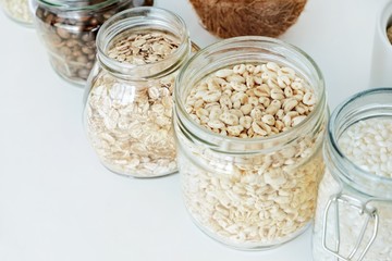 Various raw cereals, grains in glass jars. The concept of zero waste, food storage in the kitchen, healthy nutrition. Copy space for text.