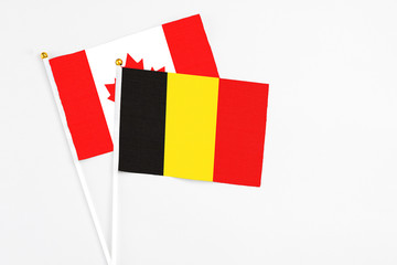 Belgium and Canada stick flags on white background. High quality fabric, miniature national flag. Peaceful global concept.White floor for copy space.