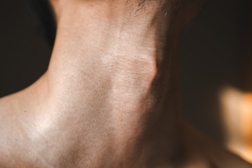 Man's neck with Adam's apple a part of body men humen anatomy close up shot. - obrazy, fototapety, plakaty