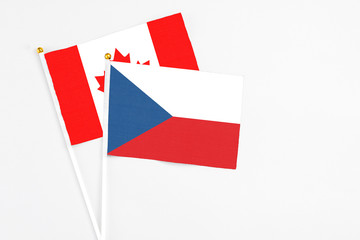 Czech Republic and Canada stick flags on white background. High quality fabric, miniature national flag. Peaceful global concept.White floor for copy space.