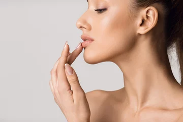 Poster Lip augmentation. Beautiful girl touching her lips © Prostock-studio