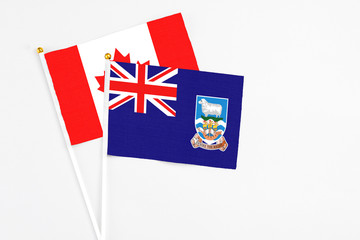 Falkland Islands and Canada stick flags on white background. High quality fabric, miniature national flag. Peaceful global concept.White floor for copy space.