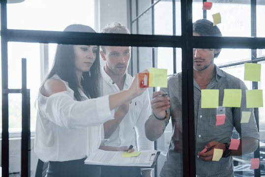 Yellow Stickers Is On The Glass. Young Business People In Formal Clothes Working In The Office