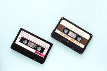 Two vintage audio tapes on a light blue background close-up. Top view
