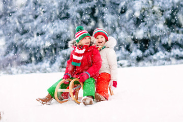 Kids play in snow. Winter sleigh ride for children