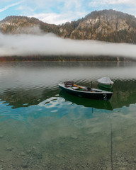 Morning fog and boats in autumn at Sylvenstein reservoir in Bavaria