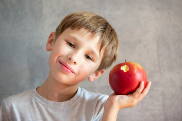 Child with fruit. Funny boy with bitten beautiful apples