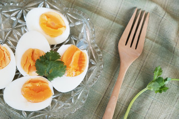 Boiled eggs cut in half, placed in a red bowl, on the tablecloth