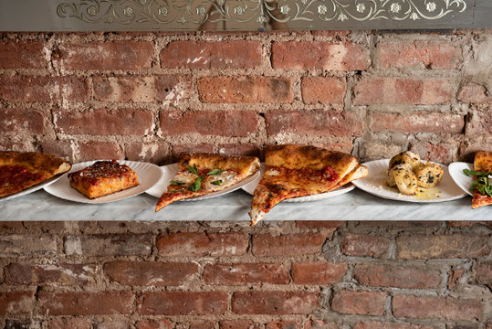 Counter full of many pizza slices