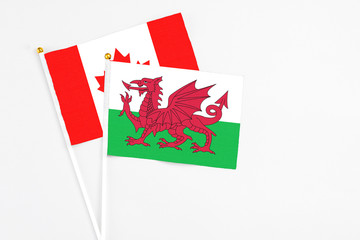 Wales and Canada stick flags on white background. High quality fabric, miniature national flag. Peaceful global concept.White floor for copy space.