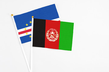 Afghanistan and Cape Verde stick flags on white background. High quality fabric, miniature national flag. Peaceful global concept.White floor for copy space.