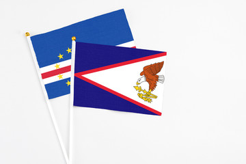 American Samoa and Cape Verde stick flags on white background. High quality fabric, miniature national flag. Peaceful global concept.White floor for copy space.