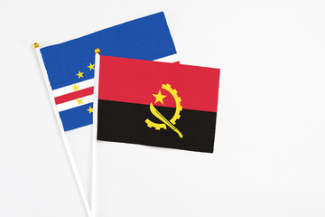 Angola and Cape Verde stick flags on white background. High quality fabric, miniature national flag. Peaceful global concept.White floor for copy space.