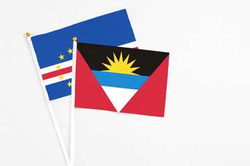 Antigua and Barbuda and Cape Verde stick flags on white background. High quality fabric, miniature national flag. Peaceful global concept.White floor for copy space.