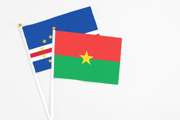 Burkina Faso and Cape Verde stick flags on white background. High quality fabric, miniature national flag. Peaceful global concept.White floor for copy space.