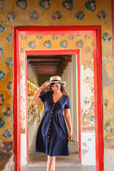 Asian beautiful girl wearing blue dress with white hat travel to Wat Arun in Bangkok, Thailand. Wat Arun is a famous tourist destination of Thailand. Travel concept
