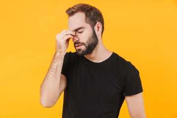 Image of displeased man touching his nose because of stress or pain