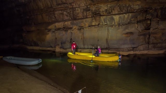 A tour guide leads a group of tourists through the deep, watery cave system at Cross Mountain, Slovenia