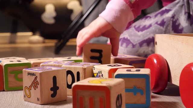 Child playing with learning building blocks with numbers and letters on them in an educational game
