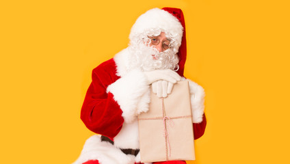 Fototapeta na wymiar Happy Santa Claus with gift winking and wishing Happy Christmas