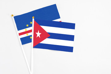 Cuba and Cape Verde stick flags on white background. High quality fabric, miniature national flag. Peaceful global concept.White floor for copy space.