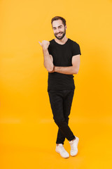 Full length image of caucasian man smiling and pointing finger aside