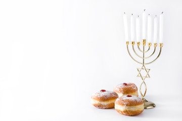 Jewish Hanukkah menorah and sufganiyot donuts isolated on white background. Copy space	