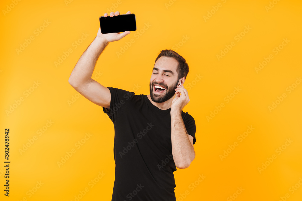 Canvas Prints Image of beautiful man in earpods listening to music with cellphone