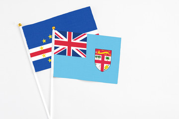 Fototapeta premium Fiji and Cape Verde stick flags on white background. High quality fabric, miniature national flag. Peaceful global concept.White floor for copy space.