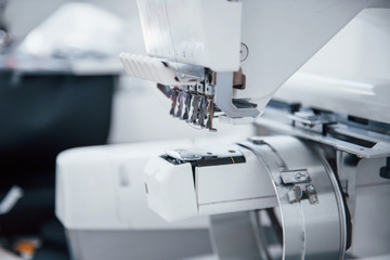 Close up view of white automatic sewing machine at factory