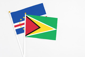 Guyana and Cape Verde stick flags on white background. High quality fabric, miniature national flag. Peaceful global concept.White floor for copy space.