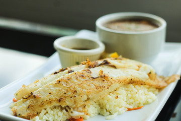 Grilled Pangasius Fillet with rice and mashed potatoes on white plate served with seafood sauce