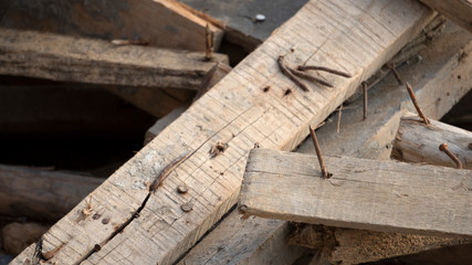 Fototapeta na wymiar Dangerous sharp tip of rusty nail on hard wood in construction area, risk to get injury accident for worker, risk management or safety concept