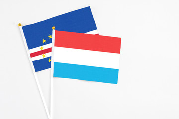Luxembourg and Cape Verde stick flags on white background. High quality fabric, miniature national flag. Peaceful global concept.White floor for copy space.