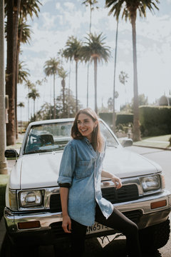 Young woman posing in Beverly Hills in front of car