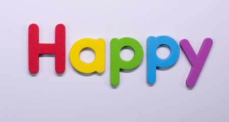 Word Happy written with color sponge