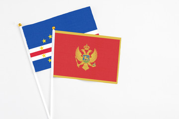 Montenegro and Cape Verde stick flags on white background. High quality fabric, miniature national flag. Peaceful global concept.White floor for copy space.