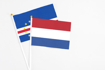 Netherlands and Cape Verde stick flags on white background. High quality fabric, miniature national flag. Peaceful global concept.White floor for copy space.