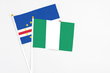 Nigeria and Cape Verde stick flags on white background. High quality fabric, miniature national flag. Peaceful global concept.White floor for copy space.